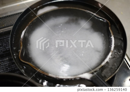 從煎鍋中取出燒焦的食物 從煎鍋中取出燒焦的食物 136259140