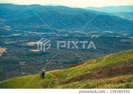 山地自行車手和滑翔傘手向下望去 136260193