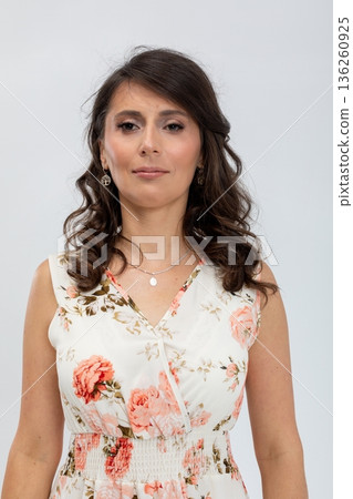 Business casual female model with polished makeup and friendly expression, Female studio portrait showcasing elegant floral attire and approachable demeanor with neutral background 136260925