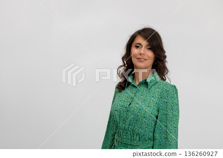 Confident woman wearing textured green dress with inviting smile, Professional lifestyle image capturing woman in bright patterned clothing with approachable demeanor Confident woman wearing textured green dress with inviting smile, Professional lifestyle image capturing woman in bright patterned clothing with approachable demeanor 136260927