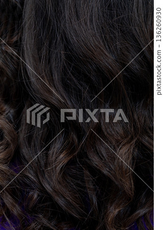 Closeup dark curly hair with glitter, stylistapplied shimmer on glossy tresses, intimate texture detail, evening beauty mood, studio lighting enhancing depth and shine Closeup dark curly hair with glitter, stylistapplied shimmer on glossy tresses, intimate texture detail, evening beauty mood, studio lighting enhancing depth and shine 136260930