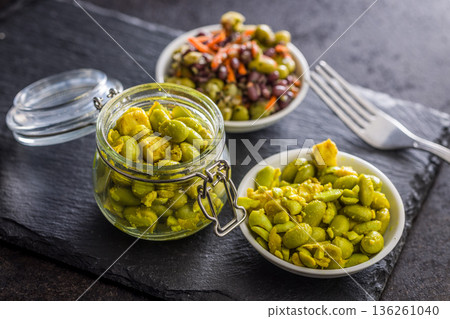 Fresh salad with edamame beans in bowl on black table. 136261040