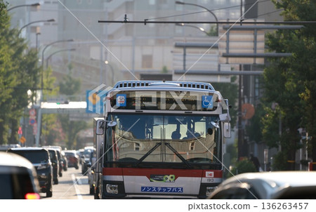 A route bus running alongside cars on a main street A route bus running alongside cars on a main street 136263457