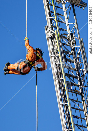 Ranger firefighters practice descending from the high ladder of a ladder-equipped fire engine during the New Year's fire drill. 136264634