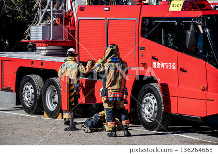 Firefighters prepare next to a fire engine to demonstrate firefighting training at the New Year's ceremony Firefighters prepare next to a fire engine to demonstrate firefighting training at the New Year's ceremony 136264663