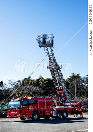 Firefighters extend the ladder of a fire engine and demonstrate rescue operations at the New Year's ceremony Firefighters extend the ladder of a fire engine and demonstrate rescue operations at the New Year's ceremony 136264682