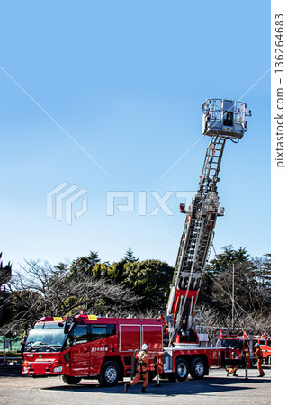 Firefighters extend the ladder of a fire engine and demonstrate rescue operations at the New Year's ceremony Firefighters extend the ladder of a fire engine and demonstrate rescue operations at the New Year's ceremony 136264683