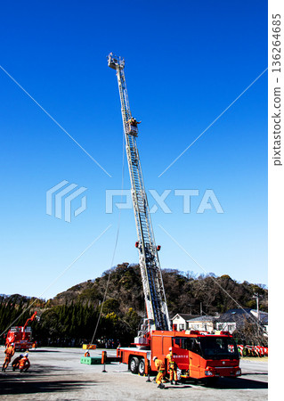Firefighters extend the ladder of a fire engine and demonstrate rescue operations at the New Year's ceremony Firefighters extend the ladder of a fire engine and demonstrate rescue operations at the New Year's ceremony 136264685
