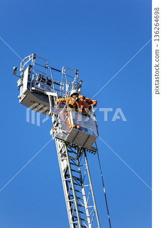 Firefighters extend the ladder of a fire engine and demonstrate rescue operations at the New Year's ceremony Firefighters extend the ladder of a fire engine and demonstrate rescue operations at the New Year's ceremony 136264698