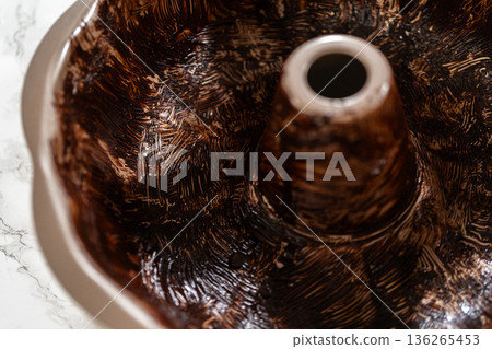 A Bundt pan coated with vegetable shortening and cocoa powder, creating a nonstick surface for the Gingerbread Bundt Cake With Caramel. This method ensures easy release and a flawless finish. A Bundt pan coated with vegetable shortening and cocoa powder, creating a nonstick surface for the Gingerbread Bundt Cake With Caramel. This method ensures easy release and a flawless finish. 136265453