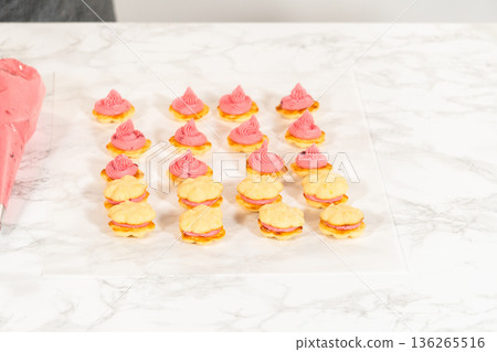 Beautifully decorated lemon spritz cookies filled with cranberry buttercream and topped with perfectly piped swirls. These vibrant treats are ideal for holiday gatherings or gifting, offering a 136265516