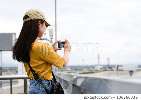 A woman photographs a factory. Photo courtesy of Kansai International Airport (KIX). A woman photographs a factory. Photo courtesy of Kansai International Airport (KIX). 136266339
