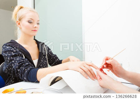 Preparing nails before manicure, pushing back cuticles 136266628