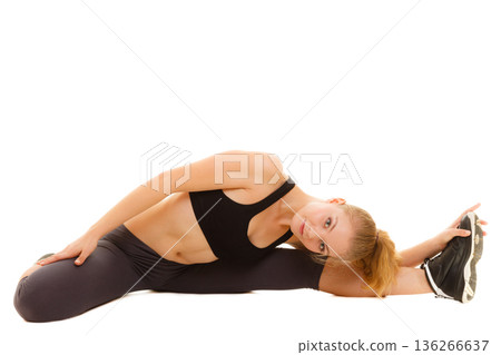 woman in sportswear doing stretching exercise woman in sportswear doing stretching exercise 136266637