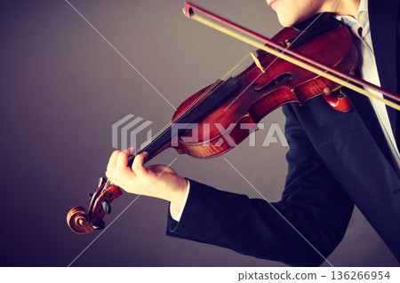 Man man dressed elegantly playing violin 136266954