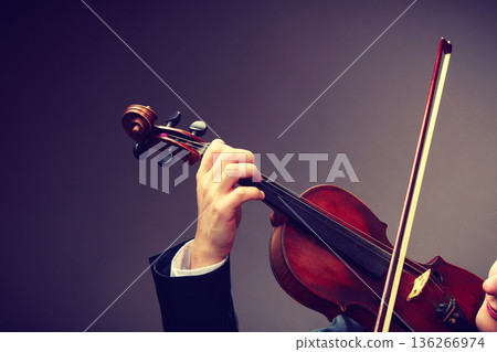 Man man dressed elegantly playing violin 136266974