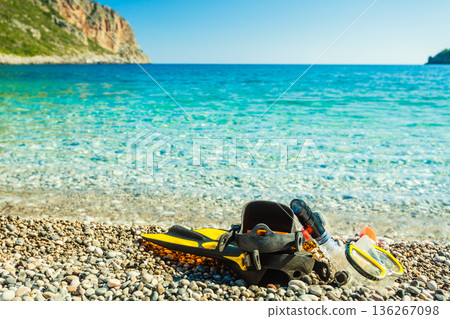 Flippers and snorkeling tube on sea shore 136267098