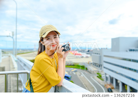 一名女子在機場手持相機。照片由關西國際機場（KIX）提供。 136267216