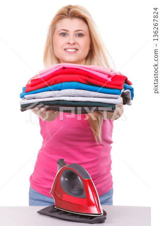 Woman holding pile of folded clothes 136267824