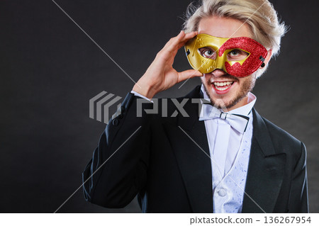 Young man in carnival mask on dark Young man in carnival mask on dark 136267954