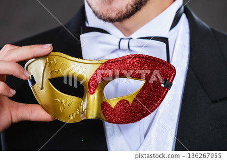Male hand holds carnival mask closeup Male hand holds carnival mask closeup 136267955
