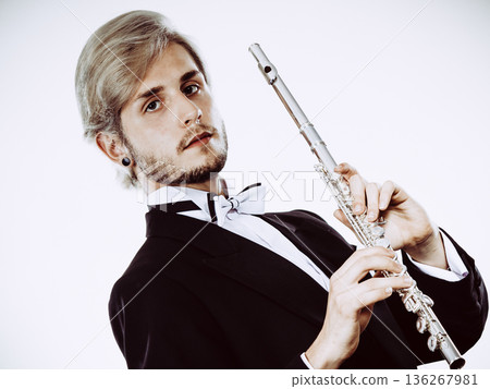Male flutist wearing tailcoat holds flute Male flutist wearing tailcoat holds flute 136267981