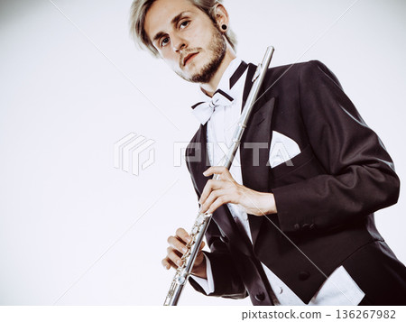 Male flutist wearing tailcoat holds flute Male flutist wearing tailcoat holds flute 136267982