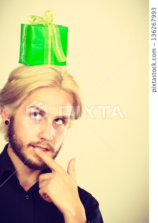 Thinking guy with green gift box on his head 136267993