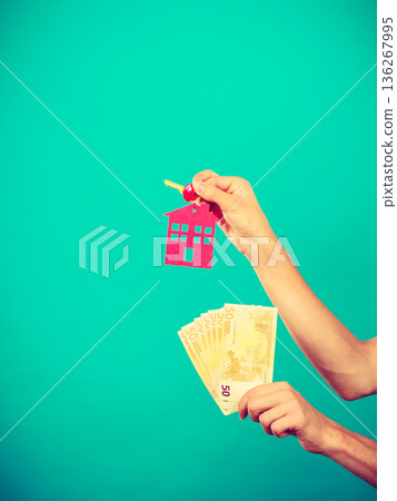 Person holding money and keys to house 136267995