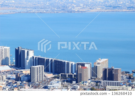 Yachts floating on the calm lake surface and high-rise apartment buildings on the lakeshore Yachts floating on the calm lake surface and high-rise apartment buildings on the lakeshore 136268410