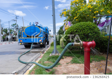 Red hydrant with hose plugs in case of emergency on a sidewalk. Red hydrant with hose plugs in case of emergency on a sidewalk. 136268425