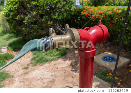 Red hydrant with hose plugs in case of emergency on a sidewalk. 136268429