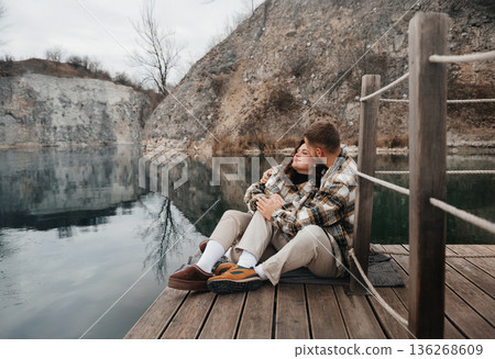 Couple enjoys time by the water on Valentines Day while embracing and sharing love in a serene setting 136268609