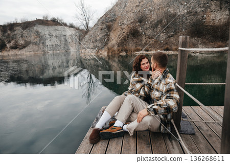 Couple shares a moment on a wooden dock by the water during Valentines Day celebration in winter season Couple shares a moment on a wooden dock by the water during Valentines Day celebration in winter season 136268611