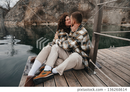 Couple enjoying a moment together on a dock by the water during Valentines Day Couple enjoying a moment together on a dock by the water during Valentines Day 136268614