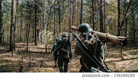 German soldiers marching with Panzerschreck anti-tank weapon in woods 136269289