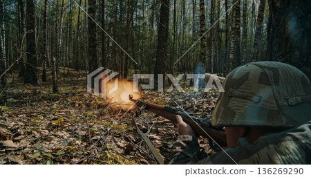 German soldier firing rifle with muzzle flash in forest battle 136269290