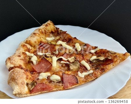 A close-up shot of a large classic pizza with cheese, ham, and mushrooms. A delicious, nutritious, and quick meal. A close-up shot of a large classic pizza with cheese, ham, and mushrooms. A delicious, nutritious, and quick meal. 136269458