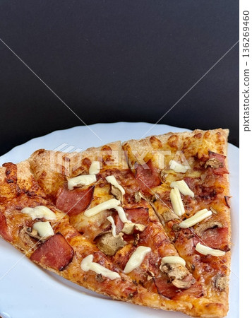 A close-up shot of a large classic pizza with cheese, ham, and mushrooms. A delicious, nutritious, and quick meal. A close-up shot of a large classic pizza with cheese, ham, and mushrooms. A delicious, nutritious, and quick meal. 136269460