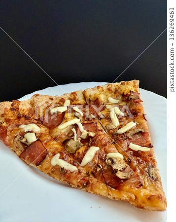 A close-up shot of a large classic pizza with cheese, ham, and mushrooms. A delicious, nutritious, and quick meal. 136269461