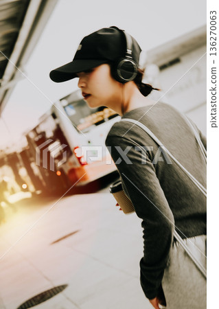 一位女士手持耳機和一杯咖啡。照片由關西國際機場（KIX）提供。 136270063