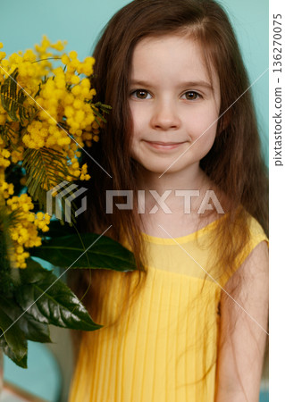 Girl with yellow mimosa bouquet on turquoise background Girl with yellow mimosa bouquet on turquoise background 136270075
