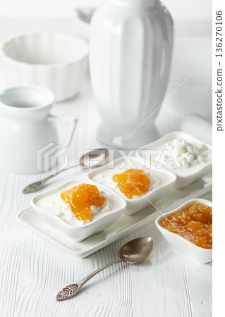 Ricotta with apricot jam  on a white table. 136270106