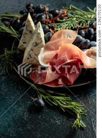 Prosciutto with blue cheese, grapes, and rosemary. 136270110