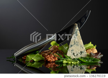 Blue cheese with knife, walnuts and fresh greens. Blue cheese with knife, walnuts and fresh greens. 136270119