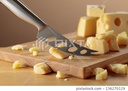 Parmesan cheese and knife on a cutting board. Parmesan cheese and knife on a cutting board. 136270129
