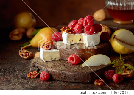 Camembert cheese with pears, fresh raspberries and walnuts. 136270133