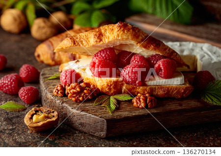 Croissant with camembert cheese, raspberries and walnuts. Croissant with camembert cheese, raspberries and walnuts. 136270134