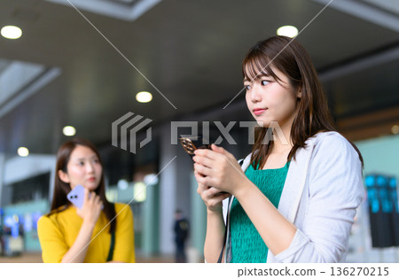 一名女子在車站使用智慧型手機。照片由關西國際機場(KIX)提供。 一名女子在車站使用智慧型手機。照片由關西國際機場(KIX)提供。 136270215
