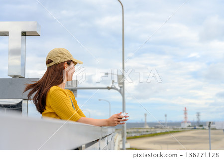 A woman looking at the scenery at the airport. Photo courtesy of Kansai International Airport (KIX). A woman looking at the scenery at the airport. Photo courtesy of Kansai International Airport (KIX). 136271128